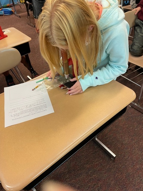 student looking into microscope